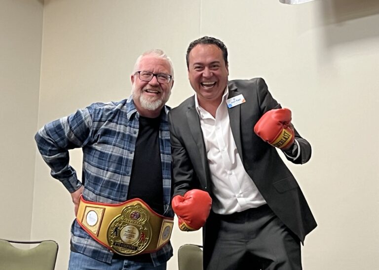 Pictured is Matt VanAuken, CEO and Executive Director of DP, wearing a boxing themed belt, and Josh Rael, Executive Director of Alliance, wearing boxing gloves.