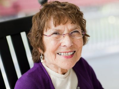 Older woman in a purple blazer smiling